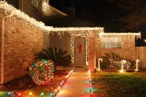 Brick ranch at night with lights along the walkway and the roofline